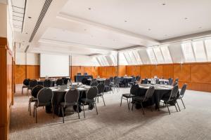 伦敦千禧国际伦敦骑士桥酒店的一间会议室,配有桌椅和投影屏幕