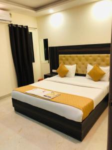 新德里Hotel IBY的一间卧室配有一张带黄色枕头的大床
