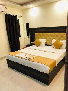 新德里Hotel IBY的一间卧室配有一张带黄色枕头的大床