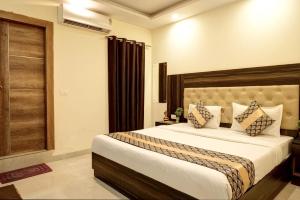 新德里Hotel IBY的一间卧室,卧室内配有一张大床