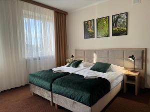 卡托维兹扎伦泽酒店的一间卧室配有一张带绿毯的大床