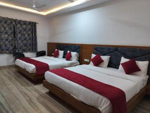 乌代浦Hotel Brij Palace & Restaurant的酒店客房 - 带两张带红色枕头的床