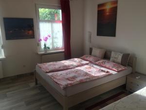 特拉森海德Ferienwohnung mit Terrasse - Insel Usedom的一间卧室配有一张带粉色床单的床和一扇窗户。
