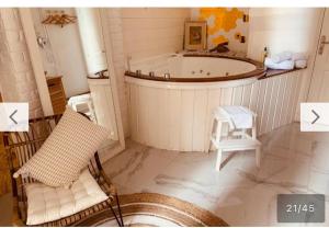 戛纳New Suite & SPA - Cannes Centre - Croisette的带浴缸、椅子和凳子的浴室