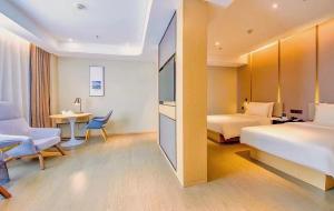 花都广州花都金融中心亚朵酒店的酒店客房配有两张床和一张书桌