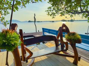 尖竹汶米纳度假酒店的木凳坐在靠近水面的码头上