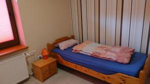 GönnernFerienwohnung Angelburg - Marburg Biedenkopf mit Balkon und Badewanne的一间小卧室,配有一张带蓝色床单的木床
