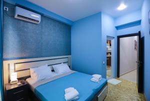 库塔伊西Hotel Sagu的蓝色的卧室,配有一张蓝色墙壁的床