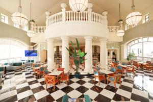 华城市拉菲多度假酒店的餐厅设有配有桌椅的大堂