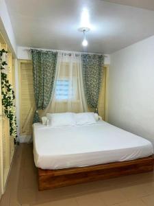 戈亚夫Villa de 3 chambres avec piscine privee jardin clos et wifi a Goyave a 6 km de la plage的卧室配有白色的床和窗户