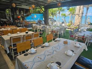 邦萨雷Condo Centerviews Bangsaray Beach的一间设有桌椅的海景餐厅