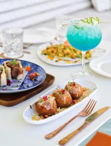 圣安东尼奥湾Grand Paradiso Ibiza - Adults Only的餐桌,餐盘和饮料