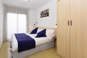 卡里拉Neptuno Apartments的一间卧室配有一张带蓝色枕头的大床