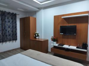乌代浦Hotel Brij Palace & Restaurant的配有一张床和一台平面电视的酒店客房