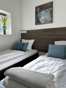 奥胡斯麦嘉华公寓酒店 的卧室配有两张床,墙上设有一个花瓶