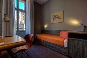 马赛阿历克斯Spa酒店的一间卧室配有一张床、一张书桌和一个窗户。