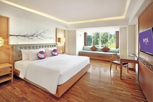 金巴兰FOX Hotel Jimbaran Beach的卧室配有一张白色的大床和一张沙发。