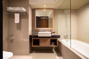 金巴兰FOX Hotel Jimbaran Beach的浴室配有盥洗盆、镜子和浴缸