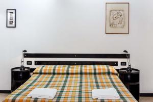 热那亚凯罗利酒店的一间卧室配有一张床,上面有两条毛巾