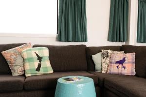 派西亚群岛湾（派西亚）哈卡山林小屋旅舍的客厅配有棕色沙发和绿色窗帘