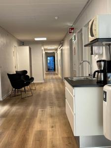 希茨海尔斯Hirtshals Idrætscenter - Vandrehjem - Hostel的办公室走廊,带厨房和椅子