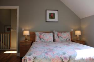 肯梅尔Cosy Holidayhomes Kerry的一间卧室配有一张带花卉床罩和两盏灯的床。