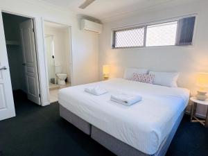 PimpamaSerenity Park Escape at Pimpama的卧室配有一张白色大床和两条毛巾