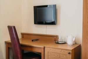 维尔纽斯CATHEDRAL HOTEL Self-check in的客房设有一张桌子,墙上配有电视。