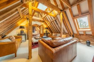 Belchamp OttenHuge luxury loft cottage in historic country estate - Belchamp Hall Hayloft的客厅设有皮革家具和木制天花板。