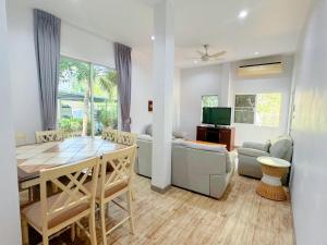 拉威海滩Rawai Valley Resort的一间带桌子的客厅和一间餐厅