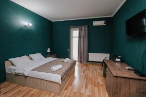 第比利斯达奇酒店的一间卧室设有一张带绿色墙壁的大床