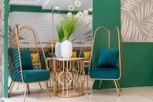 胡志明市El Ocaso Boutique Hotel的两把椅子和一张桌子,上面有花瓶
