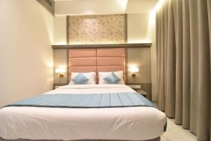 塞恩La Dhalia By Glitz Hotels的卧室配有带蓝色枕头的大型白色床