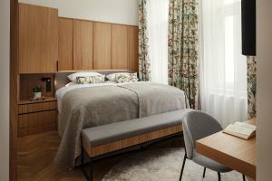 布拉格R16 Residences Prague的一间卧室配有一张床、一把椅子和一张桌子