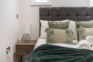 伦敦Spacious Luxury Apartment King Bed - Central Location的一间卧室配有一张带绿床单和枕头的床。