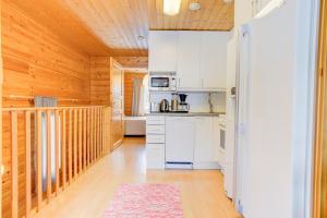 普哈圣山Pyhäkoti Holiday Home的一间厨房,配有白色家电和木制天花板