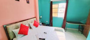瓦拉纳西Hotel Ananya Inn的卧室配有带红色枕头的白色床