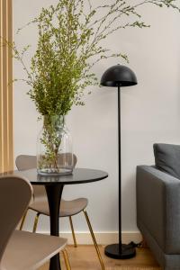 开普敦Newlands Peak Aparthotel by Totalstay的黑色地板灯和花瓶桌子