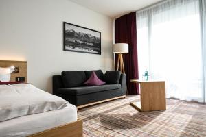 肯普滕Soloplan City Resort的客厅配有沙发和1张床
