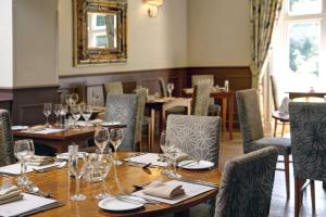 艾恩布里奇贝斯特维斯特山谷酒店的用餐室配有桌椅和酒杯