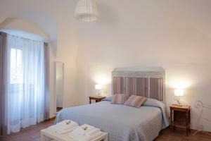 奥维多Casa Vèra Camelia Apartment的一间卧室配有一张带两张桌子和两盏灯的床。