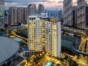 马尼拉Novotel Manila Araneta City Hotel的城市的一座有灯光的建筑