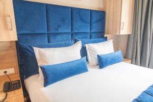 拉巴特Rent-inn Boutique Hotel的一间卧室配有蓝色床头板和一张带枕头的床