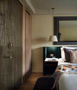 伦敦伦敦夏利酒店的一间卧室配有一张床、一张桌子和一面镜子