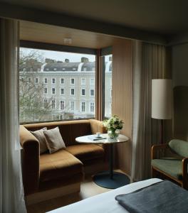 伦敦伦敦夏利酒店的酒店客房设有沙发和窗户。