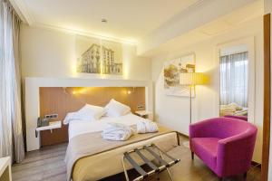 奥维多Gran Hotel España的酒店客房,配有一张床和一张紫色椅子