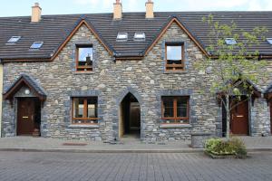 肯梅尔Cosy Holidayhomes Kerry的一座带窗户和屋顶的石头建筑