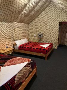 卡齐兰加Kodom Bari Retreat, Kaziranga的一间设有两张床铺的客房,位于一个天花板上