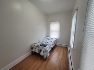 波士顿GUEST HOUSE NEAR DOWTOWN BOSTON的小卧室配有带花卉毯子的床