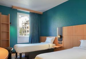 马赛B&B HOTEL Marseille Centre Vieux Port的客房设有两张床和窗户。